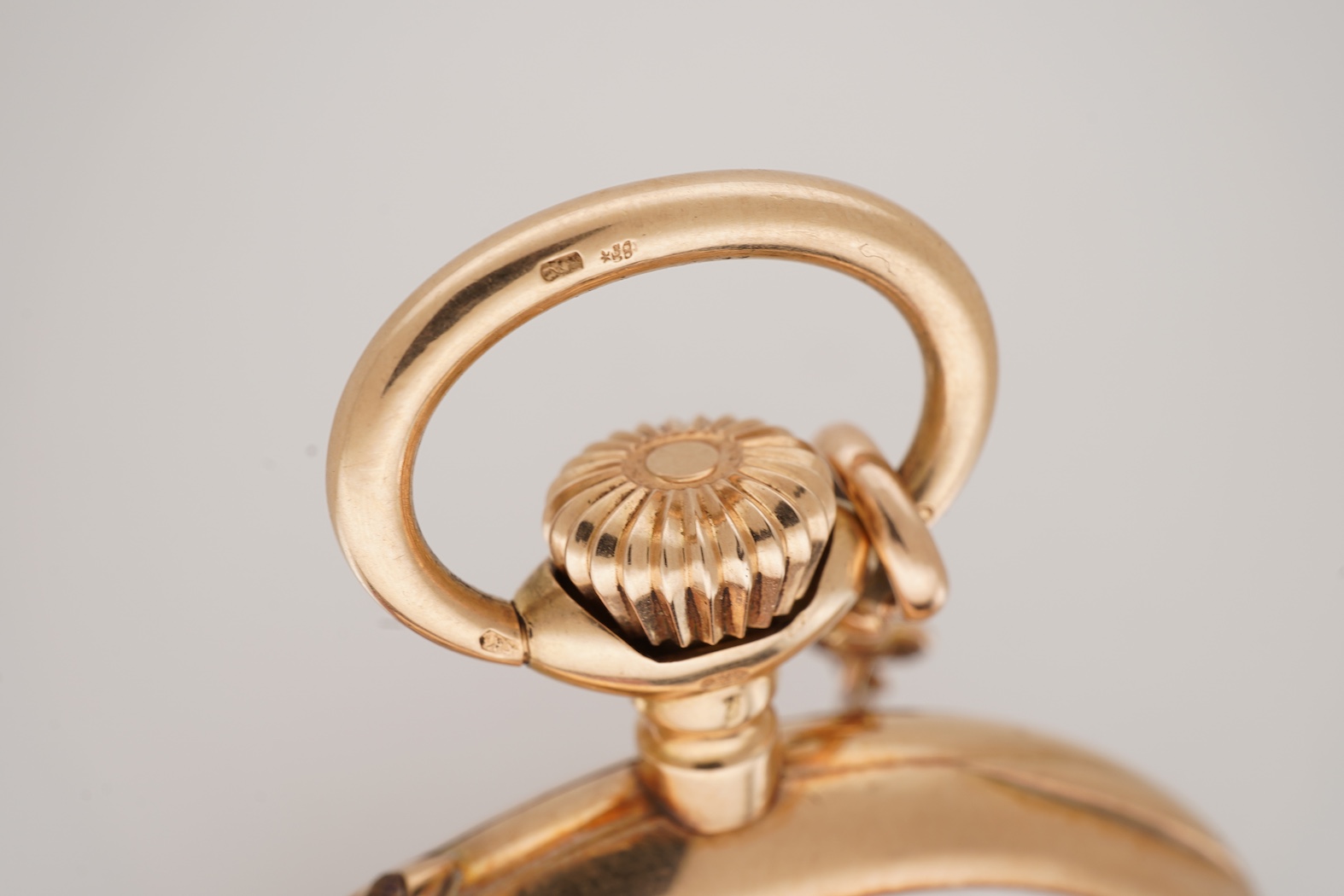 An early 20th century International Watch Company engine turned 14k yellow metal open faced keyless lever pocket watch, together with a Viennese? two colour yellow metal albert, maker's mark, LE